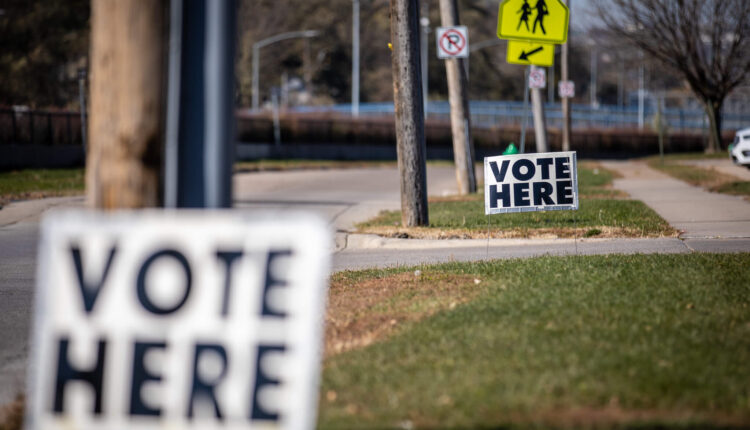 Vote Here sign in front of school crossing sign