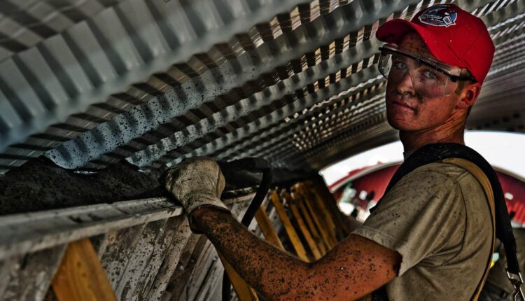 construction worker in safety googles covered in dirt and debris