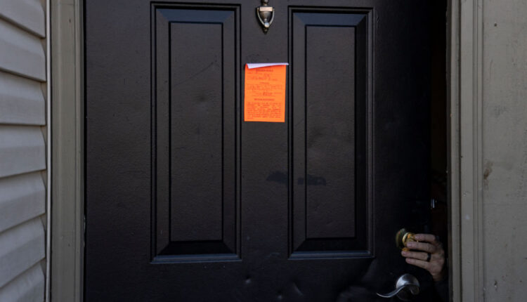 An eviction notice posted on a door as the lock is changed.