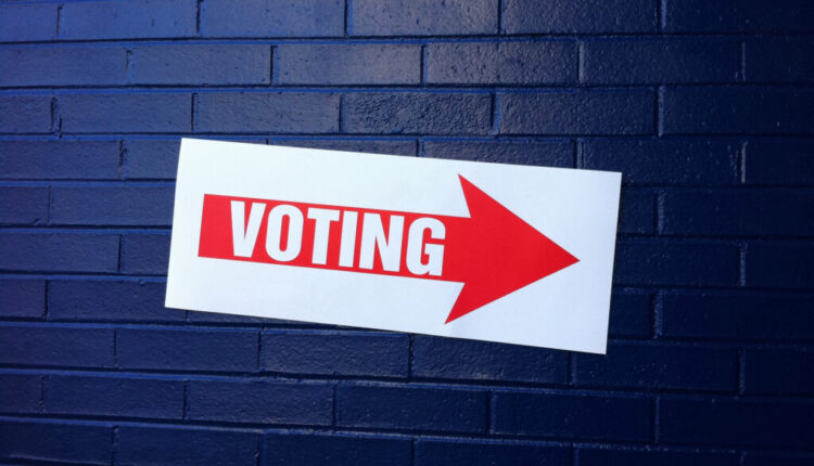 Sign on wall reads voting and points toward an election site