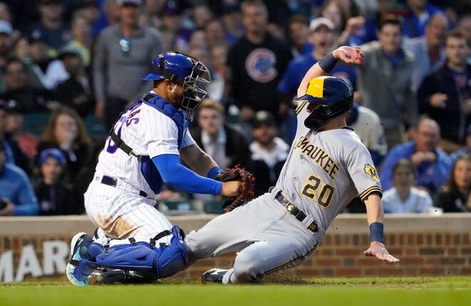 The Brewers' Mike Brosseau touches home plate just ahead of the tag of Cubs catcher Willson Contreras as he scores in the fifth inning Wednesday night.