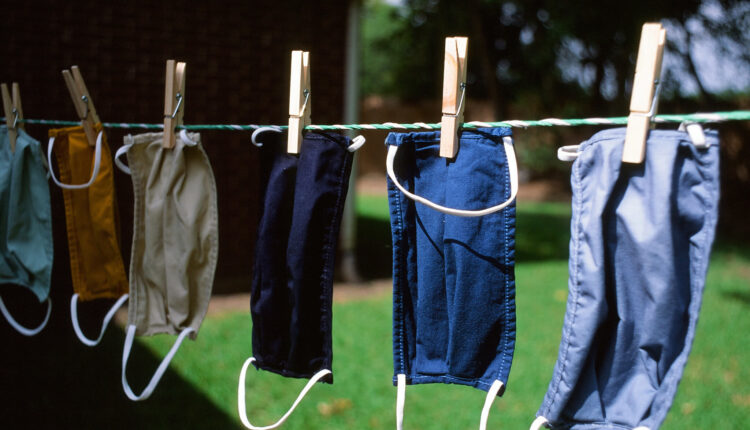 face masks in different colors hanging on a clothesline