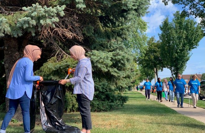 Lena Abukhamireh, left, and Leya Rizeq pick up trash during the second annual Interfaith Neighborhood Clean-up, organized by the Church of Jesus Christ of Latter-day Saints and the Islamic Society of Milwaukee, on Saturday near South 13th Street and Layton Avenue.  Abukhamireh and Rizeq are recent graduates of Marquette University, where they were leaders of the organization Students for Justice in Palestine.