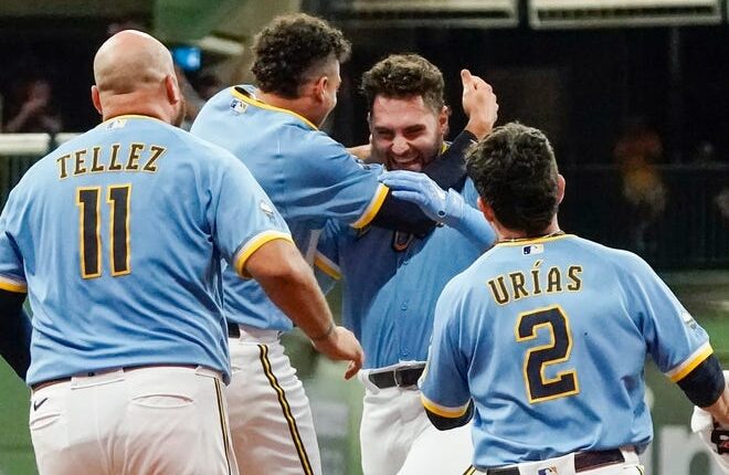 Garrett Mitchell is mobbed by his teammates after his two-out single in the ninth gave the Brewers a thrilling walk-off victory over the Yankees on Friday night.