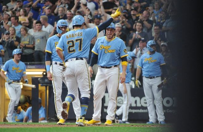 Willy Adams gets ready to touch home plate with Chrisian Yelich (left) and Victor Caratini waiting to greet him after the Brewers shortstop belted a three-run homer against the Yankees in the third inning Saturday night.