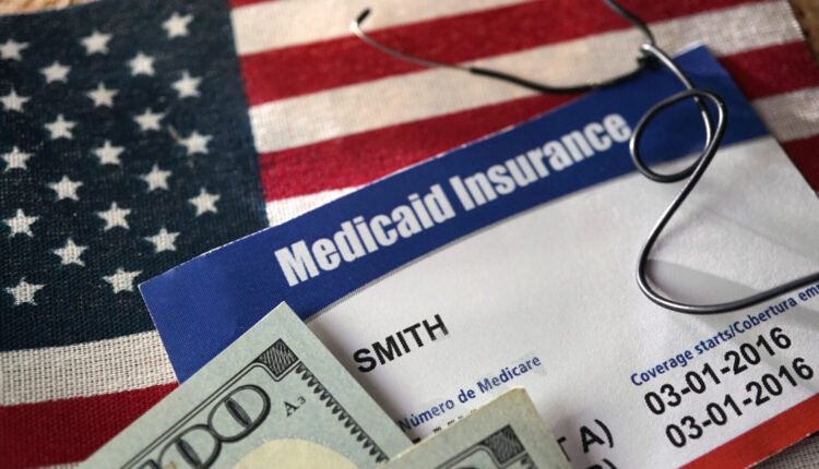 Medical theme photo with health insurance, money American flag, Medicaid card