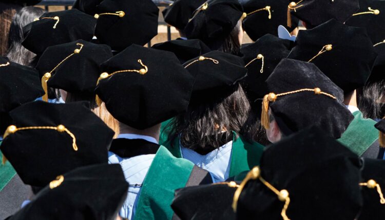 A photo of medical students at a graduation ceremony. They are seen from behind with their graduation tams and tassels facing the camera.